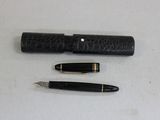 two pens and a pen holder on a table