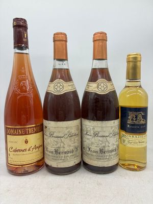 quatre bouteilles de vin sont alignées sur une table