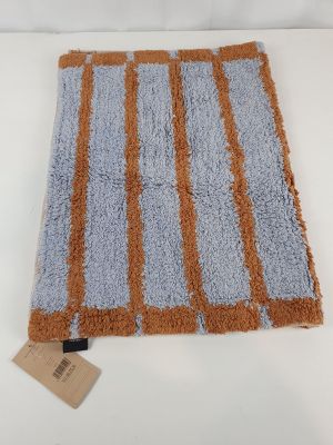 a close up of a blue and orange rug on a white surface
