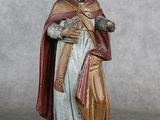 figurine représentant un homme vêtu d'une aube et tenant un livre