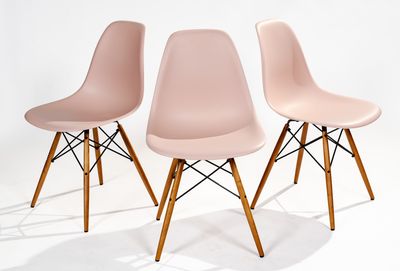 three pink chairs with wooden legs against a white background