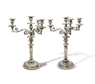 paire de chandeliers plaqués argent sur socles, sur fond blanc