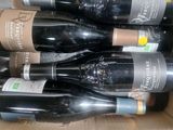 several bottles of wine are in a cardboard box on a table