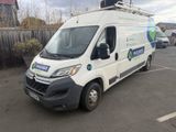une camionnette blanche garée sur un parking, près d'une clôture