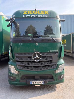 un camion vert garé devant un immeuble