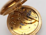 a close up of a pocket watch on a white surface