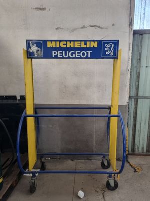 une charrette bleue et jaune avec une pancarte sur laquelle est écrit « Michel Peugeot »