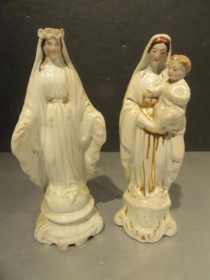 two figurines of the virgin and child are sitting on a table