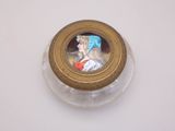 a small glass jar with a picture of a woman on it