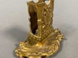 a gold candle holder with a book on it