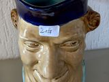 un vase bleu et marron sur lequel est représenté le visage d'un homme