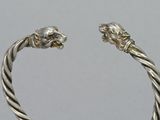 silver cuff bracelet with two lions on each side of it