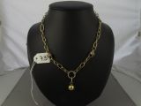 necklace with a gold ball and chain on a mannequin display