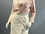 an image of a mannequin wearing a pink shirt and white skirt