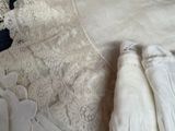 a bed with white linens and lace on it