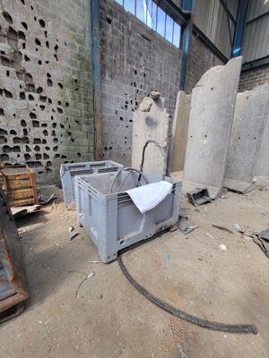 a pile of concrete blocks in a building with a broken window