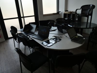 Plusieurs ordinateurs portables sont posés sur une table devant une fenêtre