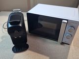 a coffee maker next to a microwave on a counter