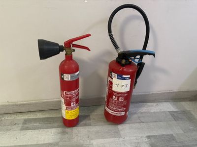 deux extincteurs placés l'un à côté de l'autre sur le sol