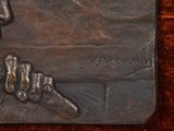 a bronze plaque of a man holding a baseball bat
