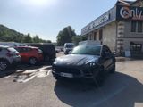 une voiture noire garée devant un bâtiment dans un parking