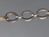 a silver watch with a chain around it on a gray background