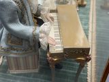 une figurine représentant une femme assise au piano