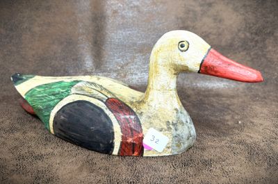 a wooden duck that is sitting on a brown surface