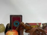 several figurines of animals and an apple on a white surface