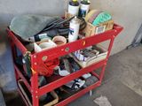 a red cart with tools on it next to a wall