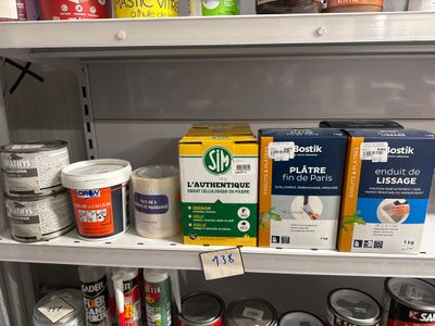 de nombreux pots de peinture sur une étagère dans un magasin