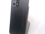 the back of a black cell phone sitting on top of a stand