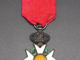a close up of a medal with a red ribbon on a table