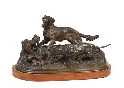 statue en bronze représentant un chien poursuivant un canard, posée sur un socle en bois