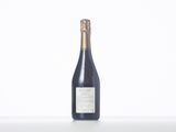 the bottle of wine is sitting on a white table