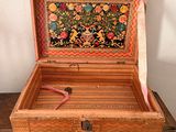 a small wooden box with a painting inside of it