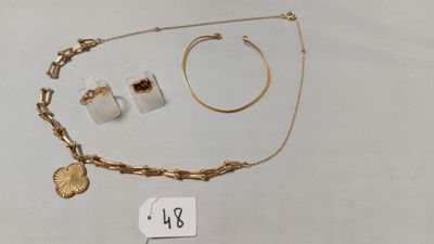 un gros plan sur un collier, un bracelet et une bague posés sur une table