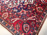 a red and blue oriental rug on a white floor