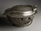 a metal bowl with a lid and handles on a table