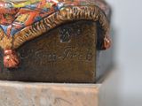 a figurine of a woman sitting on top of a box