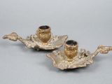 two gold colored candlesticks on a silver tray