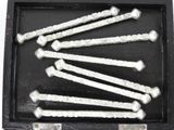 six nails in a black box on a white surface