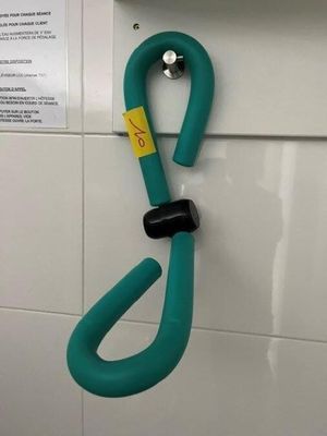 un crochet vert fixé au mur d'une salle de bains