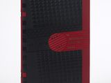 un cahier noir et rouge avec une bande rouge sur la couverture
