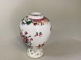 un petit vase blanc orné d'un motif floral