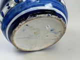 a blue and white vase sitting on a white surface