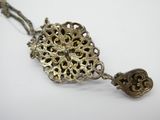 une photo d'un collier auquel est suspendu un pendentif en forme de cœur