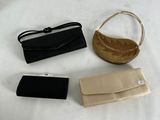 three purses and a wallet on a white table cloth