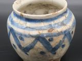 a small blue and white vase on a black surface