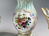two vases and a vase stand on a white surface